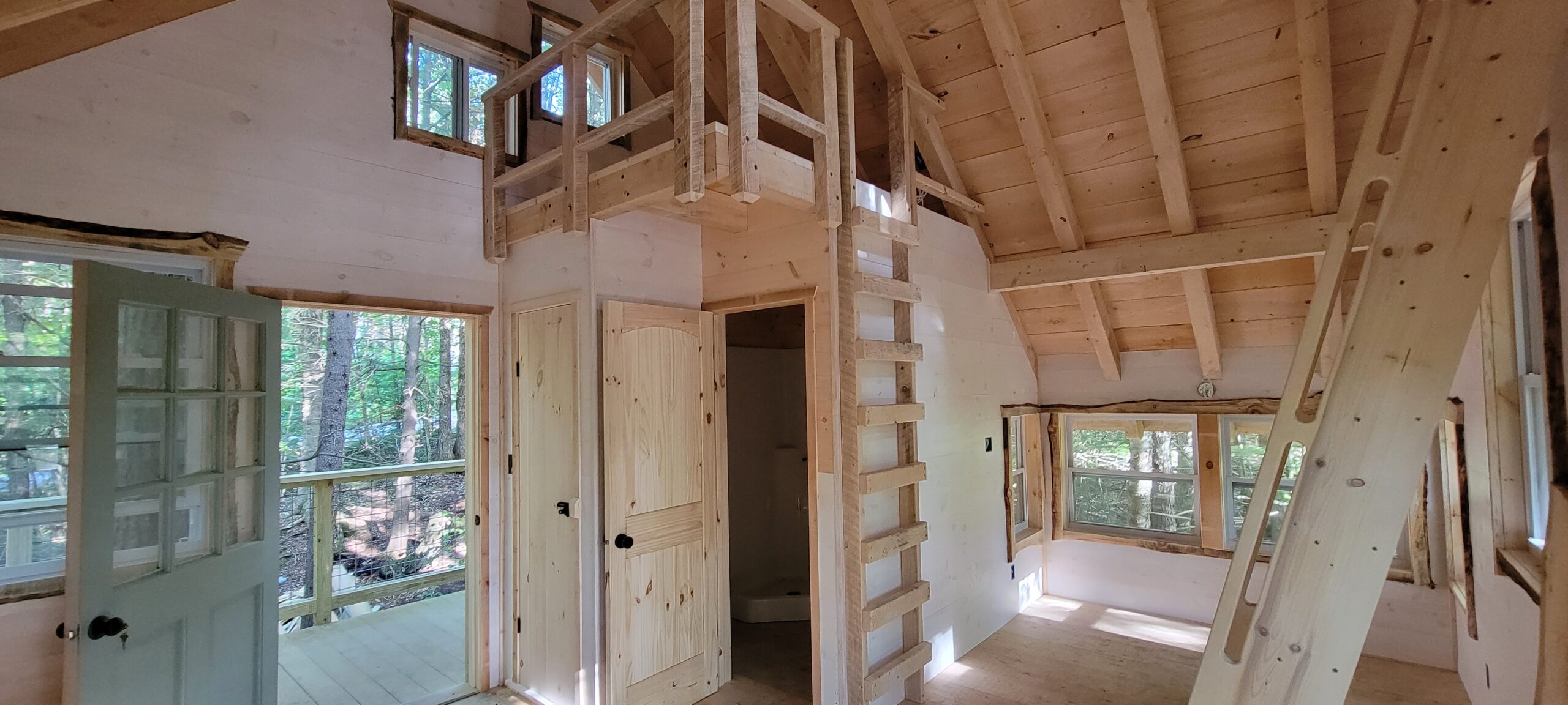 A secondary loft makes the perfect reading nook or second sleeping space in this treehouse rental.